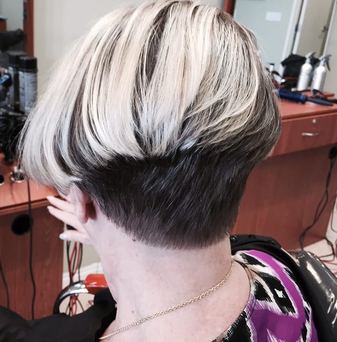 Back of a short stacked bob with platinum highlights over a dark undercut nape