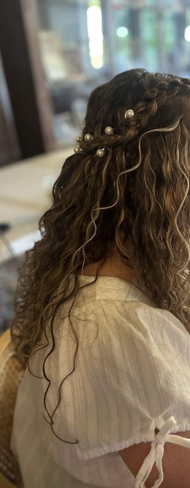 Curly highlighted hair with a small braid and pearl hair pins, seen from the side and behind