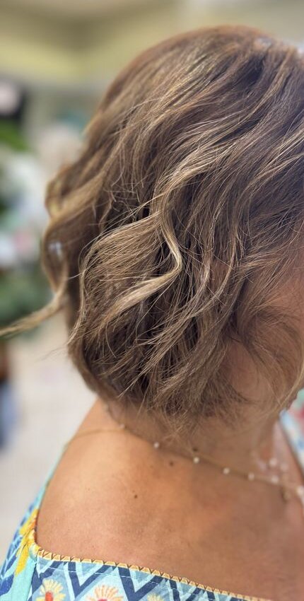 Short bob with soft waves and light highlights, seen from the side